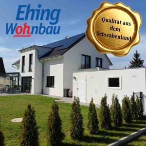 Modern white house with solar panels on the roof, green lawn, and a prominent gold quality seal reading 'Qualität aus dem schwabenland' (Ehing Wohnbau logo in the corner).