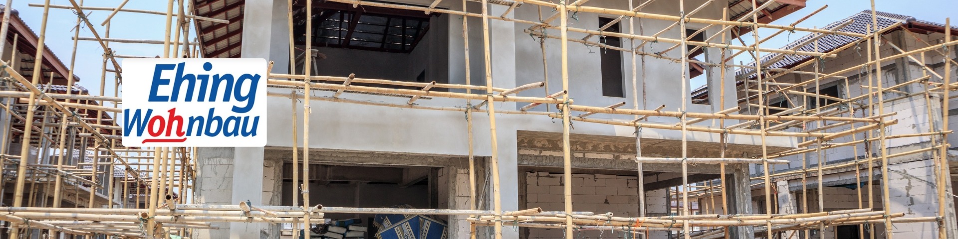 Building under construction with extensive bamboo scaffolding; left side shows a blue and red 'Eh ing Woh nbau' sign.